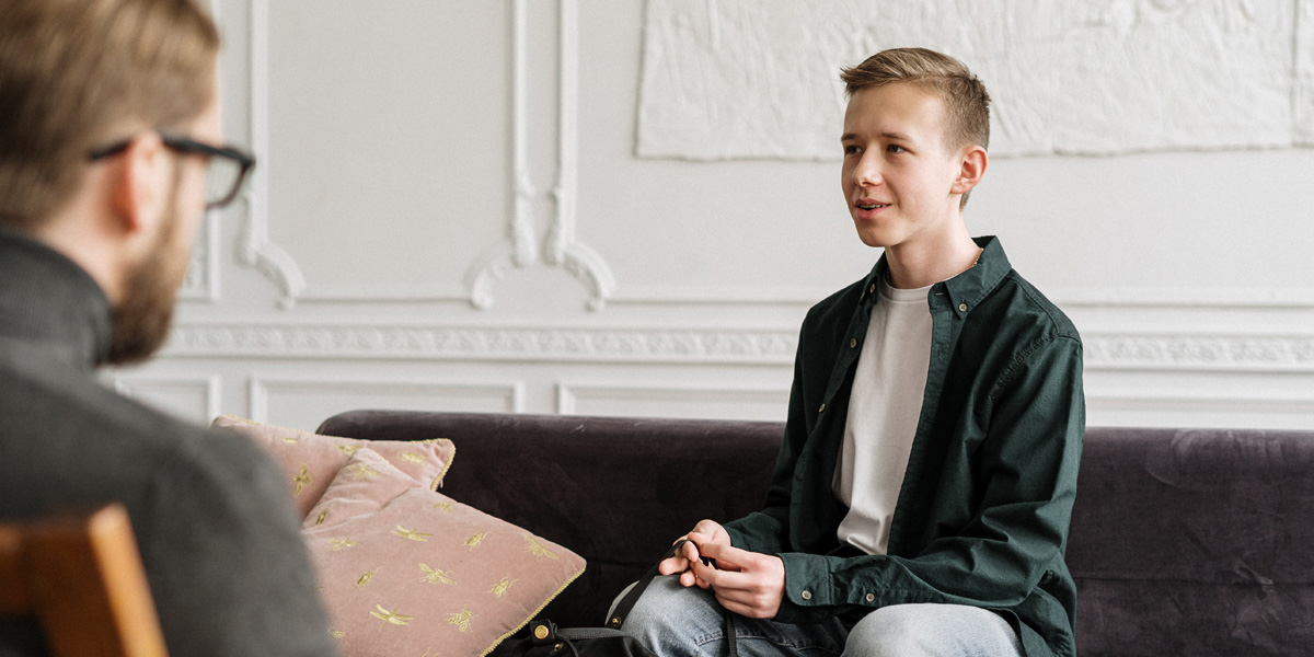 Young Person Sitting on a Couch Facing a Therapist