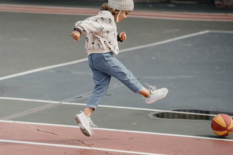 Child playing on a basketball court