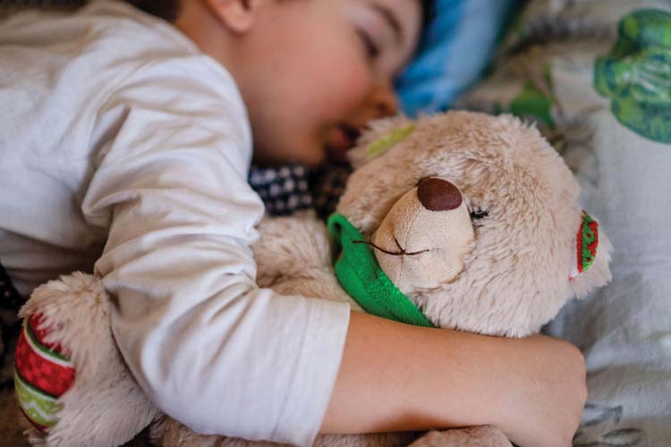 Child sleeping with teddy bear